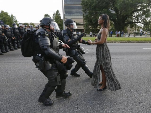 Lone activist Ieshia Evans stands her ground while offering her hands for arrest as riot police charge towards her during a protest against police brutality outside the Baton Rouge Police Department in Louisiana, U.S. on July 9, 2016.